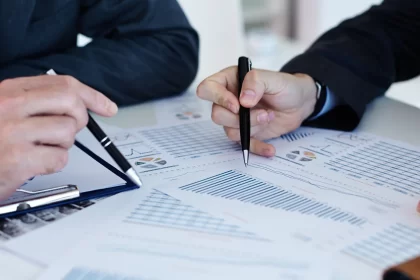 Papers with hands holding pens