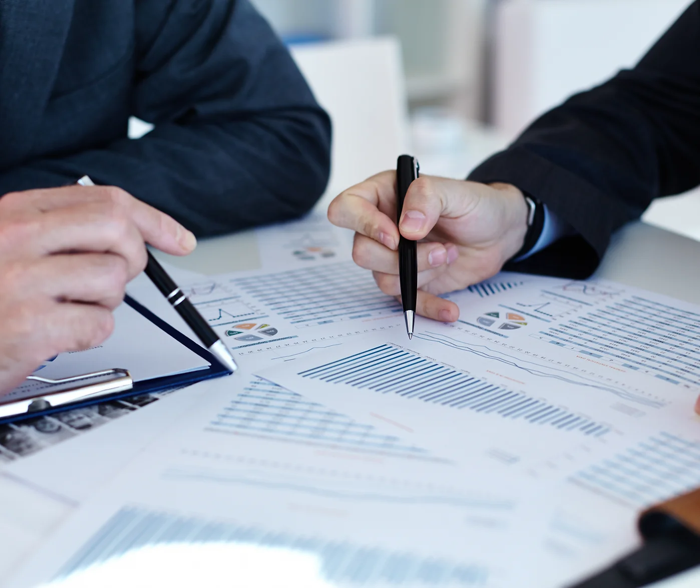 Papers with hands holding pens